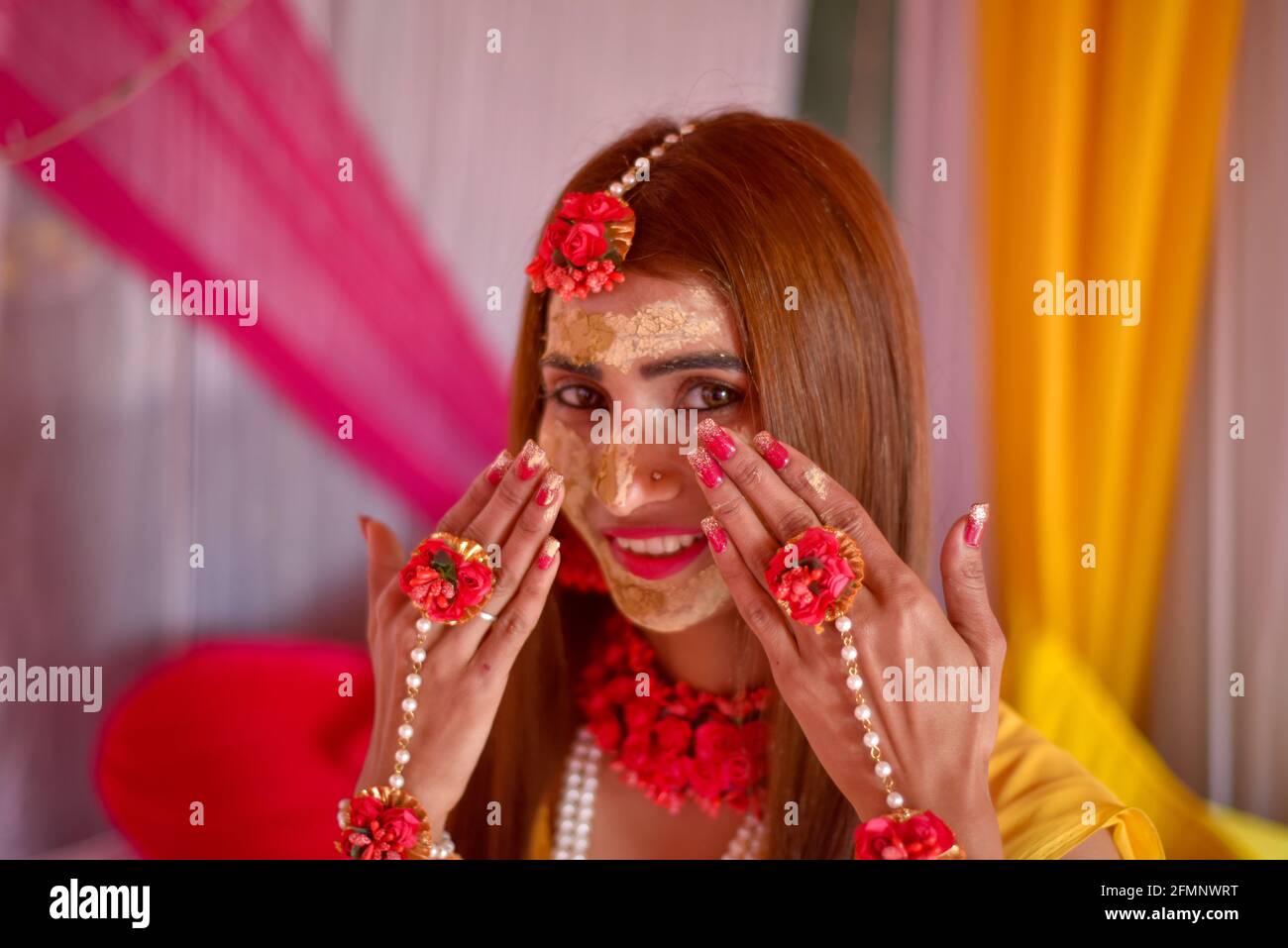 Porträt einer schönen indischen Braut mit Kurkuma haldi Paste auf ihrem Gesicht. Stockfoto