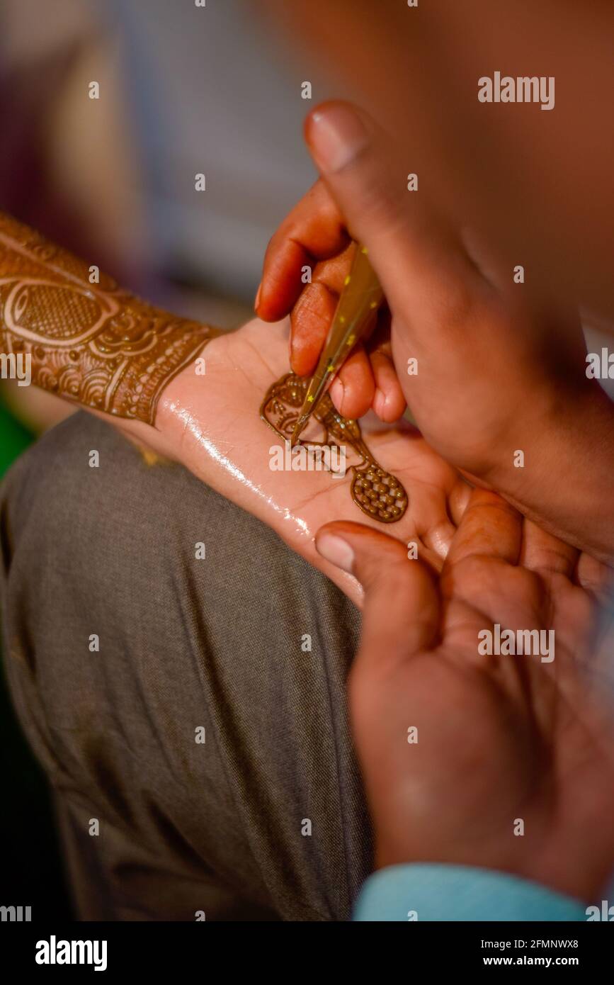Nahaufnahme der Hände der atemberaubenden indischen Braut, Anwendung Hinna auf ihre Hochzeit. Stockfoto