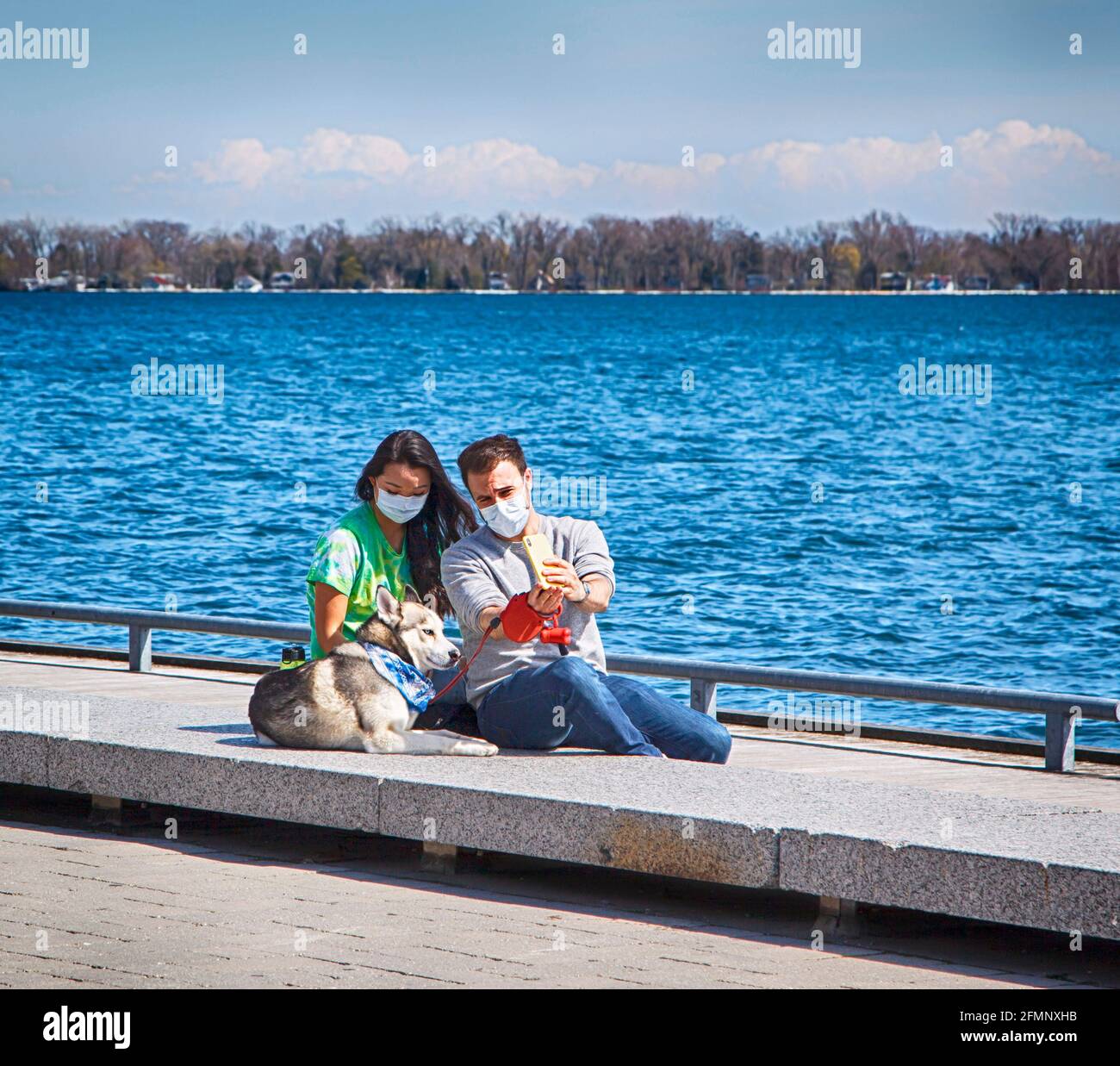 Glückliches Paar in der Liebe genießen ihre Zeit mit Haustieren in der Natur. Glückliches Paar, das ein Selfie mit seinem Hund macht Stockfoto