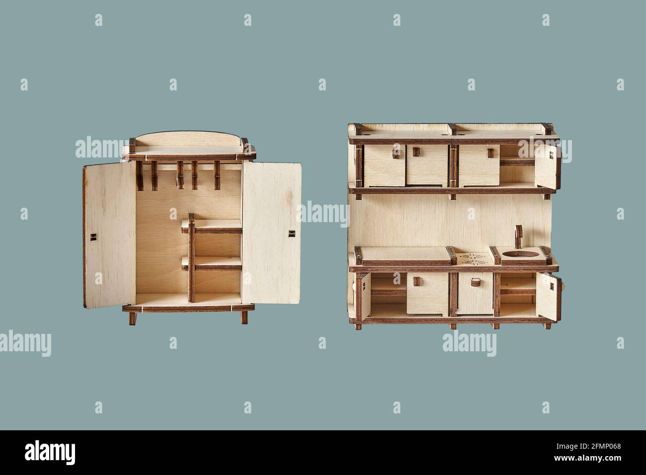 Niedliche kleine Spielzeug Garderobe und Küche Set aus Ply Holzdetails geschnitten mit Laser-Werkzeugmaschinen isoliert auf grün Hintergrund Stockfoto