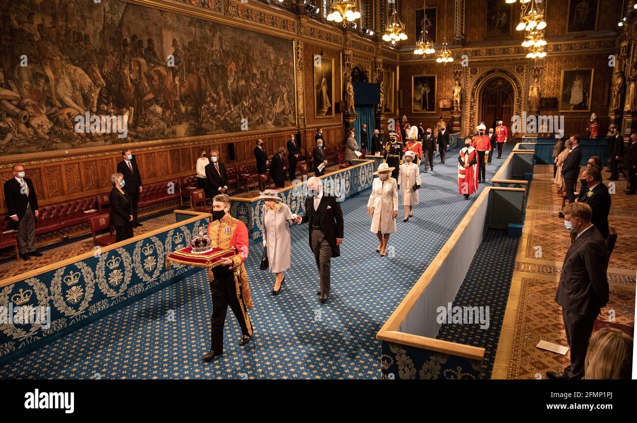Königin Elizabeth II. Geht in Begleitung des Prinzen von Wales durch die Royal Gallery, bevor sie die Rede der Königin während der Eröffnung des Parlaments im House of Lords im Palace of Westminster in London hält. Bilddatum: Dienstag, 11. Mai 2021. Stockfoto