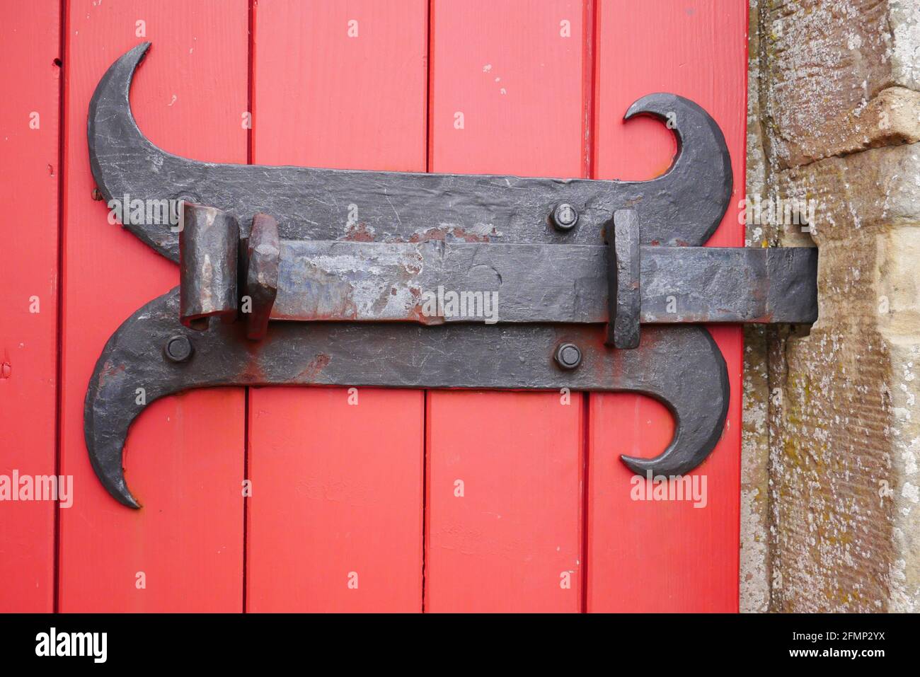 Alte kunstvolle Metallverriegelungsschraube als Türschloss an Eine rote  Holztür einer mittelalterlichen Burg Stockfotografie - Alamy