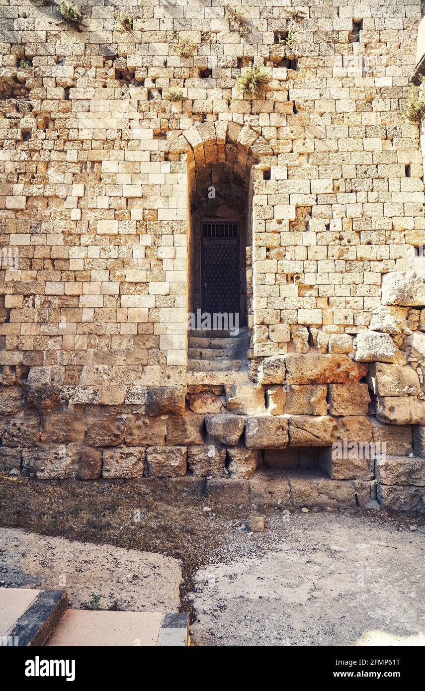 Verwitterte alte Rhodos Festung Ziegel und Steinmauer mit leer Bogen Tür unter hellem Sonnenlicht im Sommer Griechenland Stockfoto
