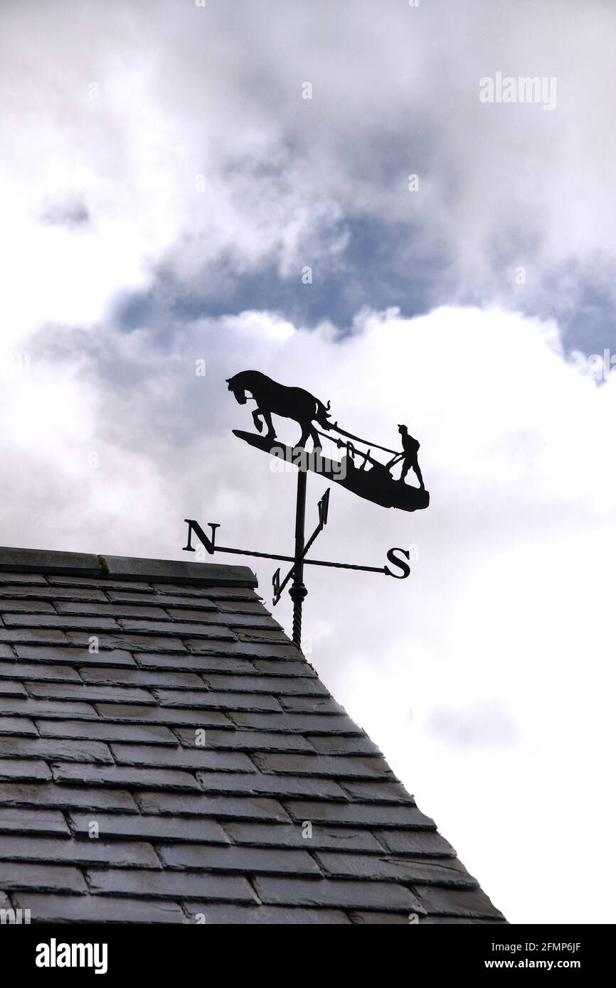 Wetterfahne im Stil eines Pferdes, das eine zieht Pflug, um die Richtung des Windes auf einem zu zeigen Farm in Großbritannien Stockfoto