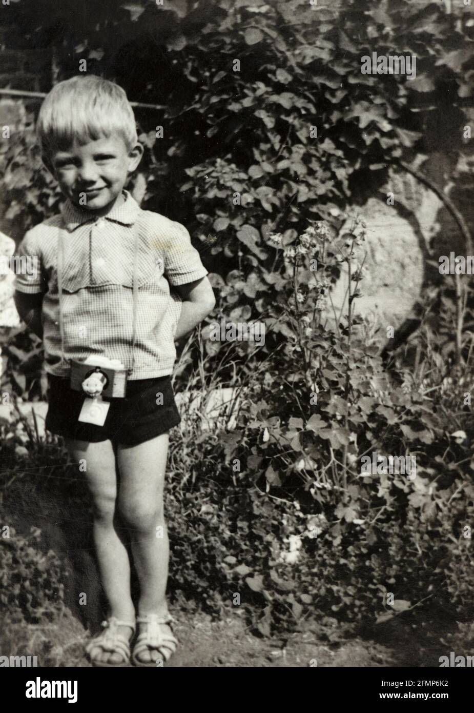 Lächelnder 4-jähriger Junge mit Spielzeug-Fotokamera ca.1970, Bulgarien Stockfoto