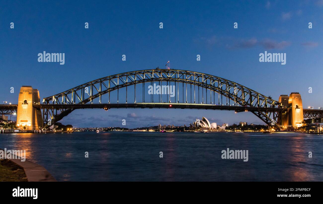Sydney Hafen während der Blauen Stunde mit einem perfekten Blick auf seine Wahrzeichen: Die Harbour Bridge und das Opernhaus Stockfoto
