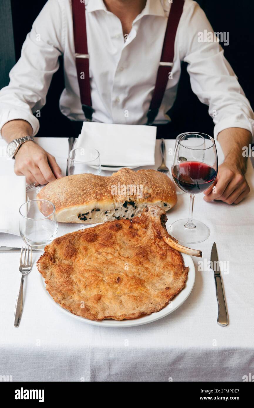Cotoletta Milanese, typisch 'Orecchia di elefante' (Elefantenohr), serviert  mit hausgemachter olivenbrad und einem Glas Rotwein, Mailand, Italien, Euro  Stockfotografie - Alamy