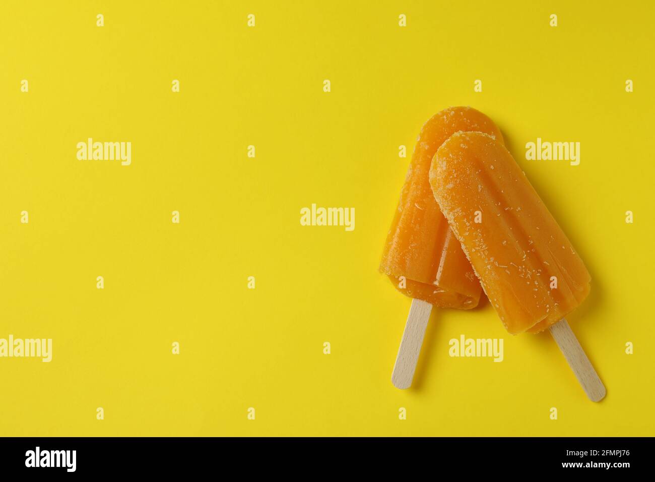 Mango-Eis-Sticks auf gelbem Hintergrund Stockfoto