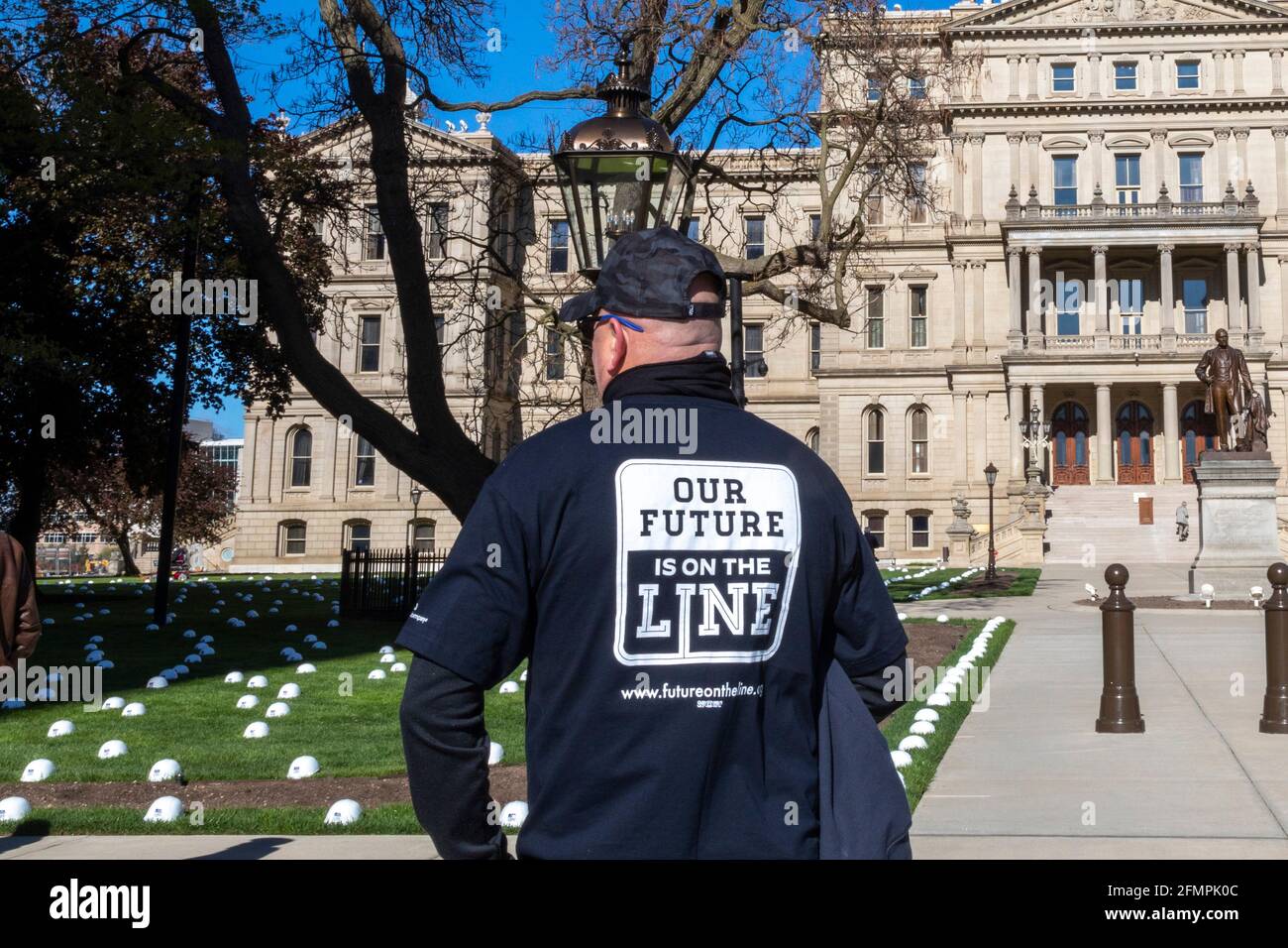 Lansing, Michigan, USA. Mai 2021. Die Mitglieder der Gewerkschaft der United Steelworkers legen harte Hüte auf den Rasen der Staatshauptstadt, um die Arbeitsplätze zu repräsentieren, die nach ihrer Meinung durch die Schließung der Enbridge Line 5, einer Ölpipeline, die unter der Straße von Mackinac verläuft, verloren gehen würden. Aus Angst, dass ein Leck eine katastrophale Verschmutzung der Großen Seen verursachen könnte, hat der Gouverneur von Michigan, Gretchen Whitmer, Enbridge angewiesen, die Pipeline zu schließen. Das Unternehmen sagt, dass es dieser Anordnung trotzen wird. Kredit: Jim West/Alamy Live Nachrichten Stockfoto