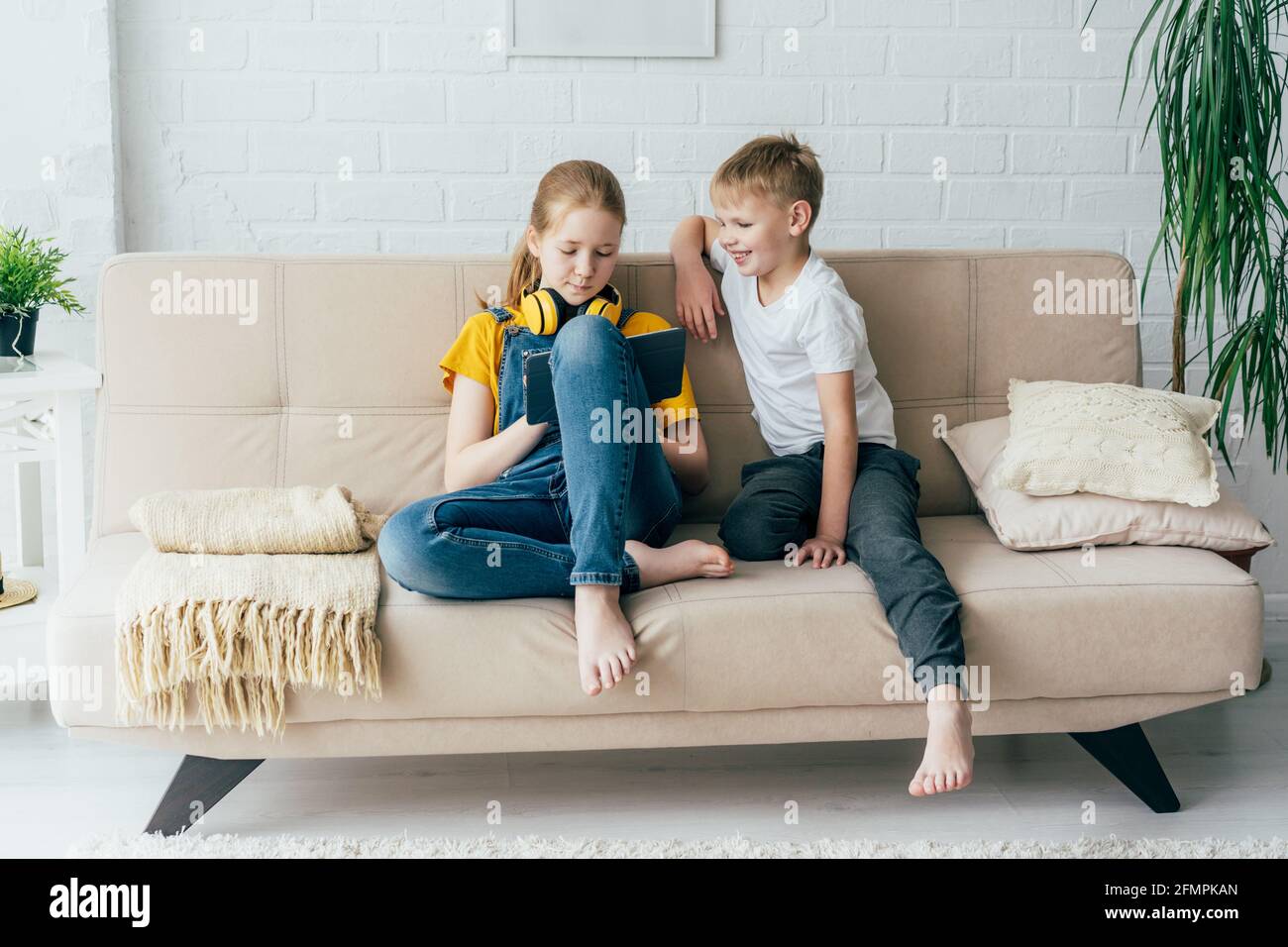 Freunde Teenager, die auf der Couch sitzen, spielen mit einem digitalen  Tablet. Kinder lernen online Stockfotografie - Alamy