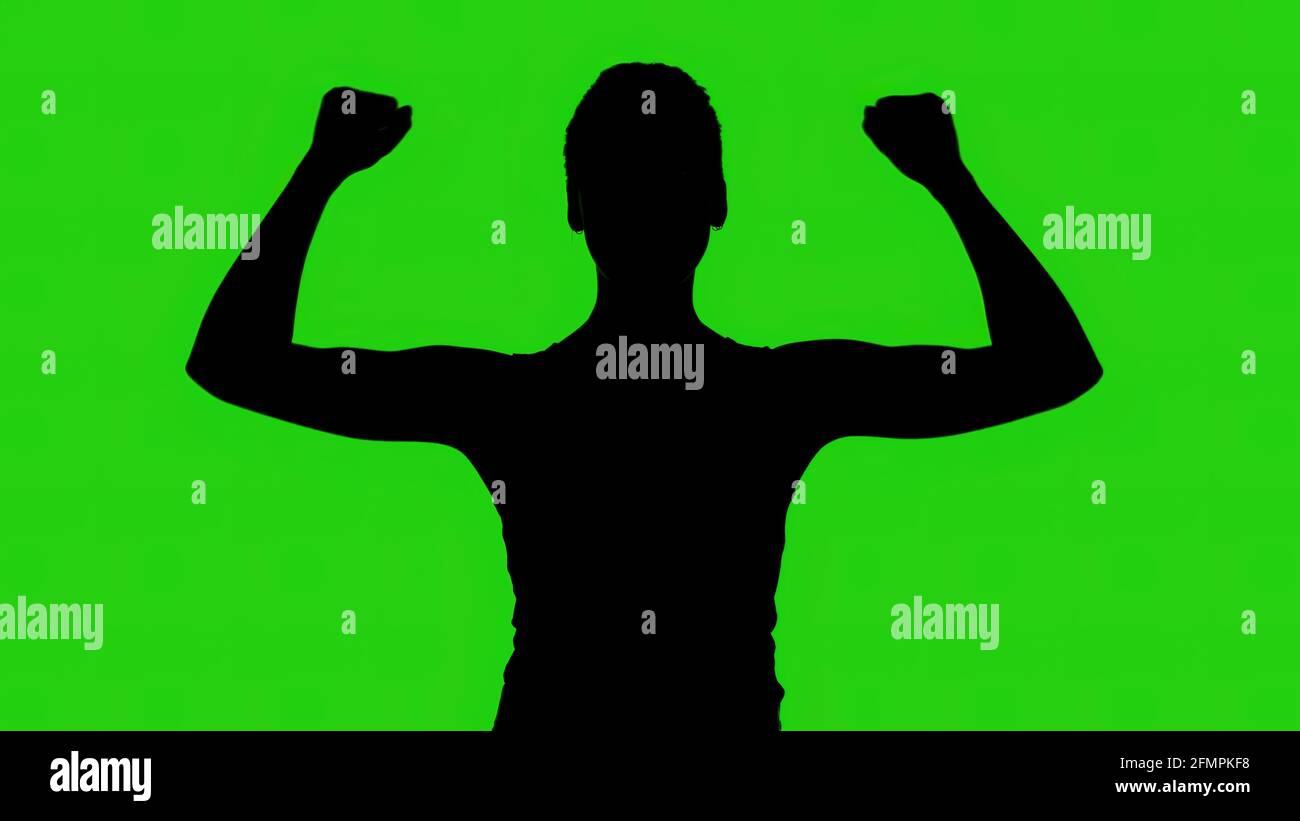 Die Silhouette der Frau mit den Händen nach oben auf grünem Hintergrund Stockfoto