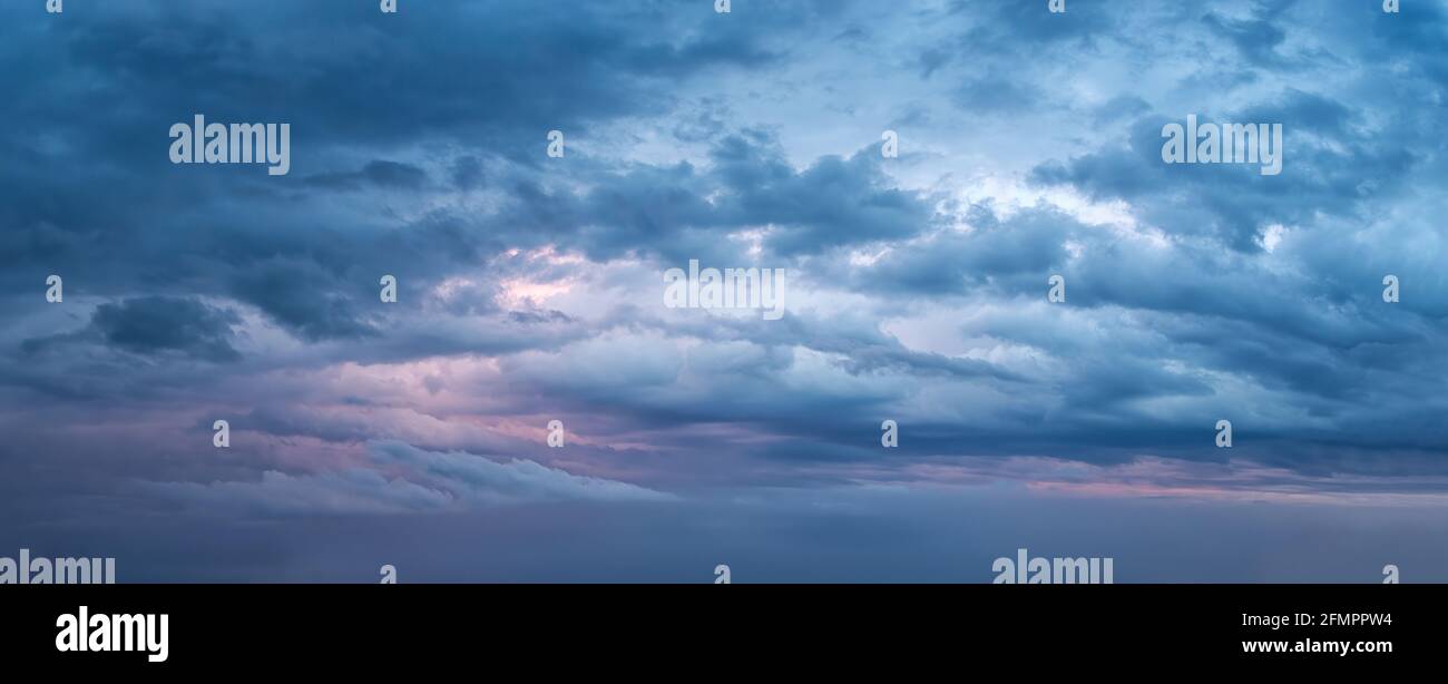 Dramatischer Himmel am Abend Panoramaaufnahme. Landschaftlich schöne blaugraue Wolken vor dem Sturm. Wolkenlandschaft vor dem Regen. Blaue Stunde stürmische Wolkenlandschaft. Stockfoto