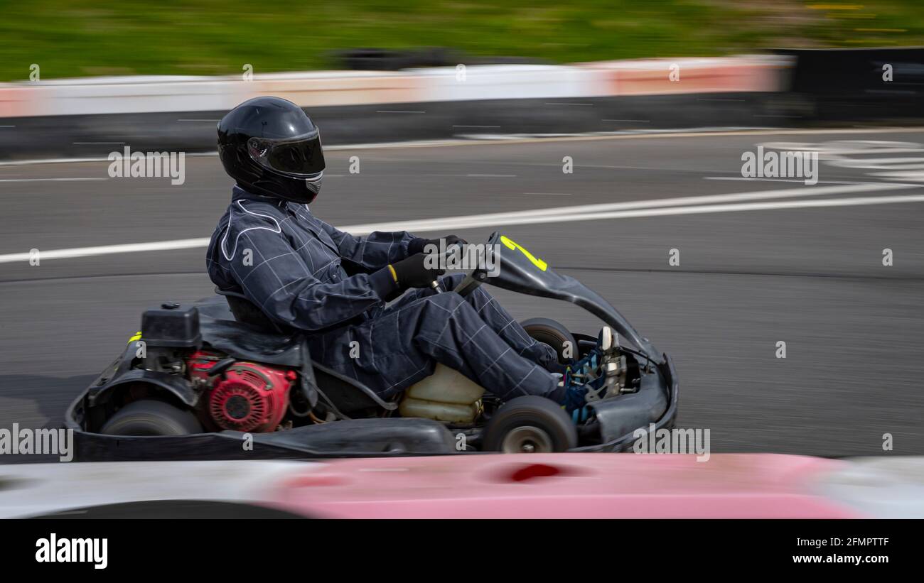 Eine Schwenkaufnahme eines Rennkarts, der auf einer Rennstrecke kreist. Stockfoto