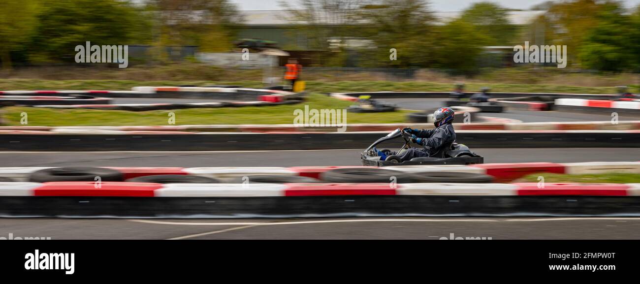 Eine Schwenkaufnahme eines Rennkarts, der auf einer Rennstrecke kreist. Stockfoto