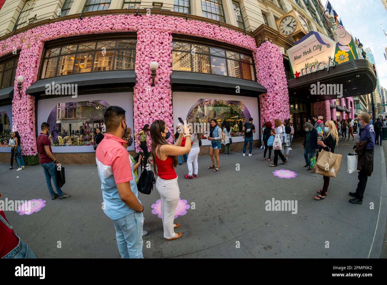 Besucher vor Macy's Flagship-Kaufhaus am Herald Square in New York, das mit Blumenarrangements für die jährliche Macy's Flower Show am Eröffnungstag Sonntag, den 2. April 2021, behauen ist. Besucher strömen zur diesjährigen Show mit dem diesjährigen Thema, Give. Liebe. Bloom.“ Die Show, die letztes Jahr aufgrund der Pandemie auf Pause war, wurde entwickelt, um soziale Distanzierungen zu fördern. Die Show läuft bis zum 16. Mai. (© Richard B. Levine) Stockfoto