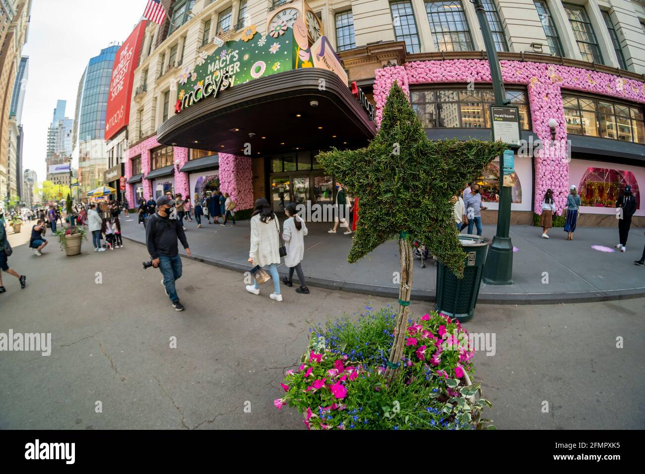 Besucher vor Macy's Flagship-Kaufhaus am Herald Square in New York, das mit Blumenarrangements für die jährliche Macy's Flower Show am Eröffnungstag Sonntag, den 2. April 2021, behauen ist. Besucher strömen zur diesjährigen Show mit dem diesjährigen Thema, Give. Liebe. Bloom.“ Die Show, die letztes Jahr aufgrund der Pandemie auf Pause war, wurde entwickelt, um soziale Distanzierungen zu fördern. Die Show läuft bis zum 16. Mai. (© Richard B. Levine) Stockfoto