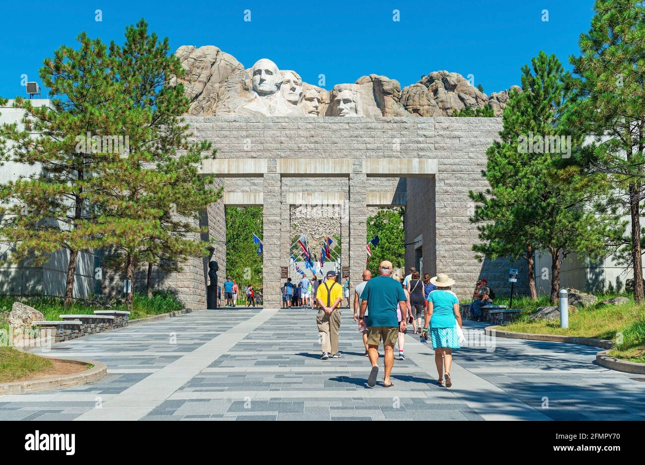 Touristen, die am Eingang des Mount Rushmore nationalen Denkmals mit den US-Präsidenten geschnitzten Gesichtern, South Dakota, USA, spazieren. Stockfoto