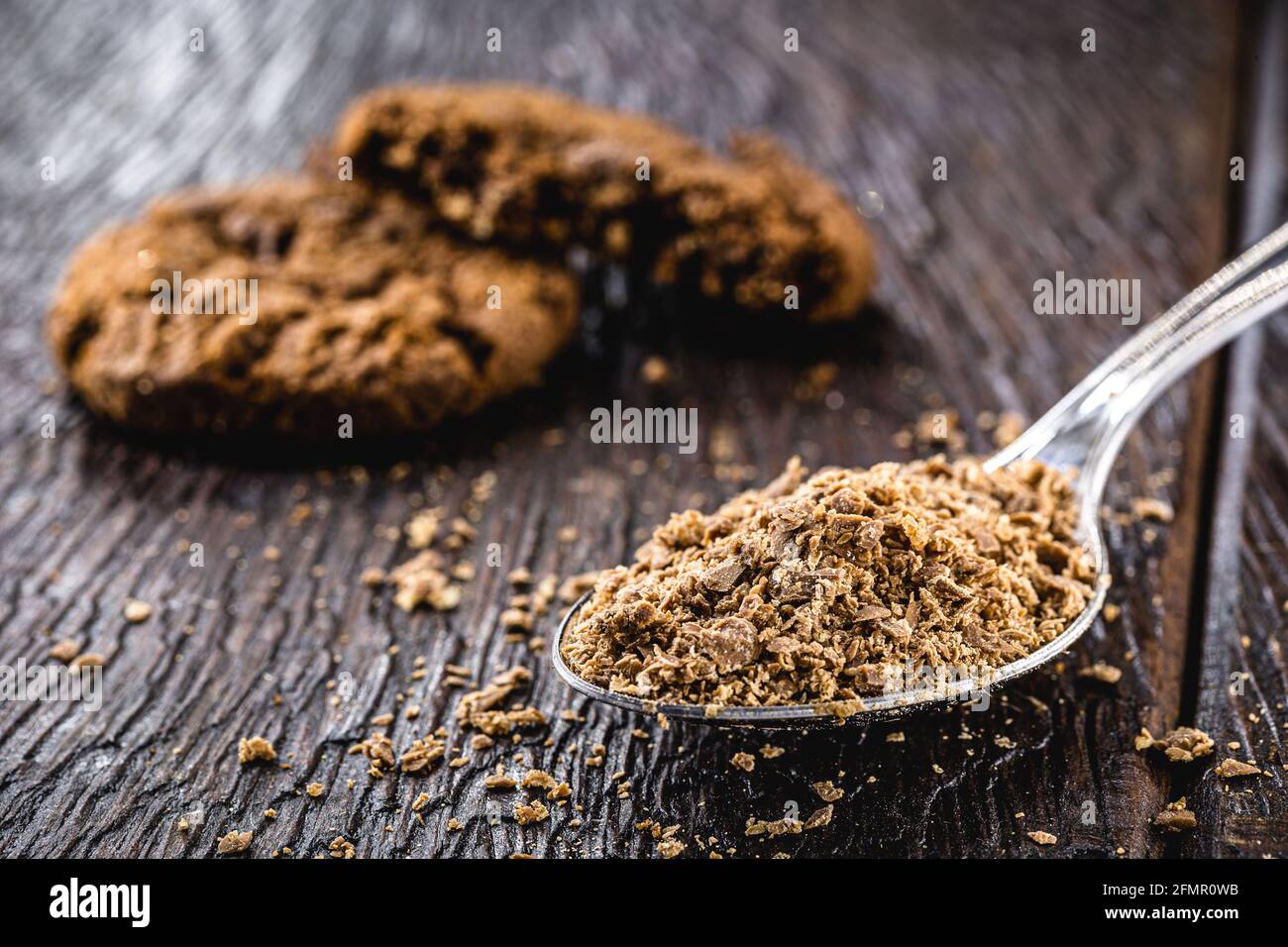 Löffel mit geriebener Schokolade, Schokoladenpulver als Cookie-Zutat verwendet Stockfoto
