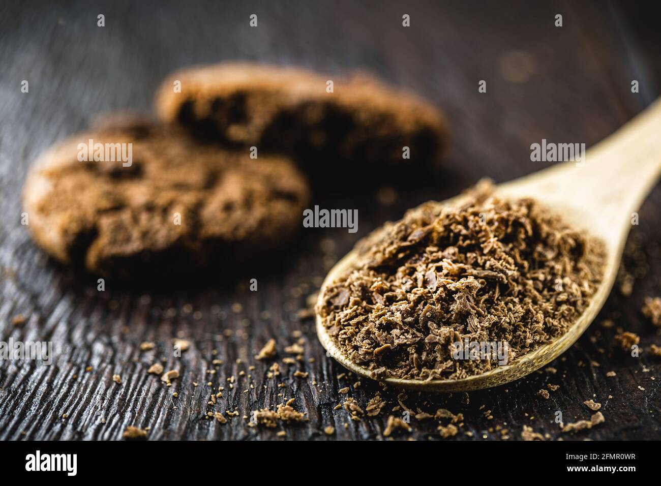 Löffel mit geriebener Schokolade, Schokoladenpulver als Cookie-Zutat verwendet Stockfoto