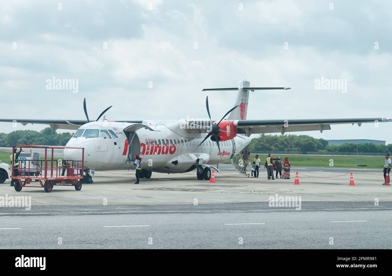 Melaka, Malaysia. 18. August 2017. Passagiere, die ein Passagierflugzeug aus dem Malindo-Flugzeug auf der Start- und Landebahn des internationalen Flughafens malacca auf einem bewölkten Flugzeug abfliegen Stockfoto