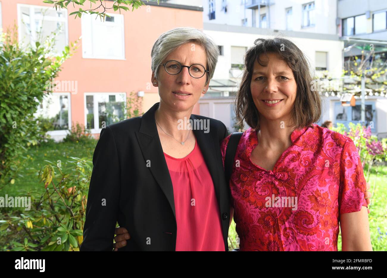 München, Deutschland. Mai 2021. Das Ehepaar Christine Walter (l.) und Almut Münster zeigen sich nach einem katholischen Gottesdienst mit Segnung homosexueller Paare im Rahmen einer bundesweiten Aktion vor der Kirche St. Benedikt. Unter dem Motto #liebeinnt laden Pastoren in ganz Deutschland um den 10. Mai zu Gottesdiensten ein, in denen homosexuelle Paare gesegnet werden können. Es handelt sich um eine Protestaktion gegen einen kürzlich veröffentlichten Brief, in dem der Vatikan diese Segnungen verboten hat. Quelle: Felix Hörhager/dpa/Alamy Live News Stockfoto