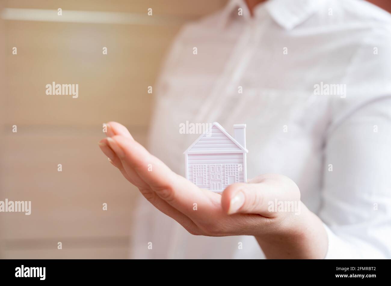 Hände halten Miniaturhaus. Wohnungs- und Hausschutz-Versicherungskonzept, Familienhaus, Hauskredit, Hausversicherung, Familienlebensversicherung Stockfoto