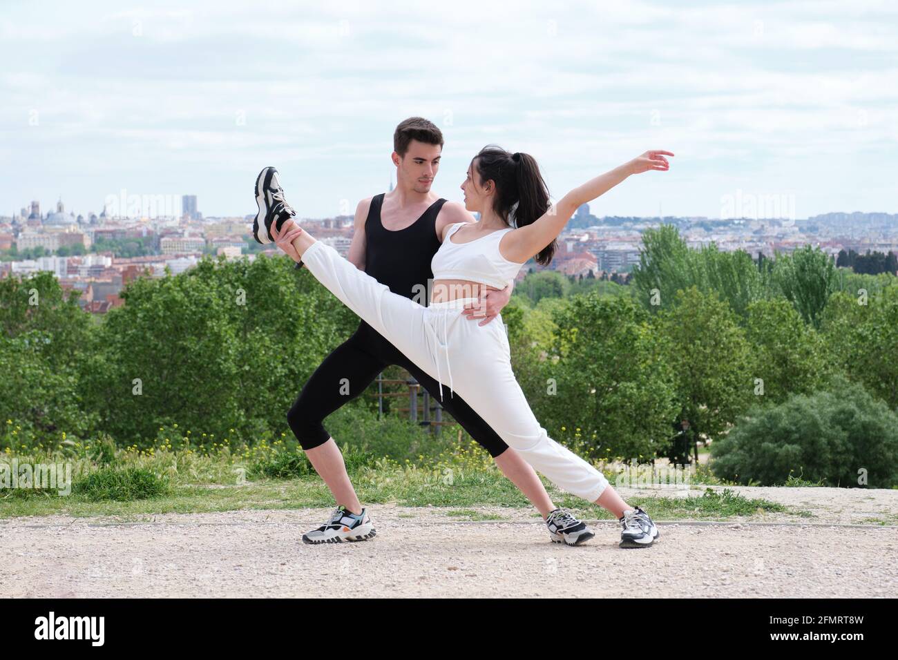 Junges Paar, das Straßentanz, Ballett, Tanzschritte und Bewegungen in einem Park praktiziert. Stockfoto
