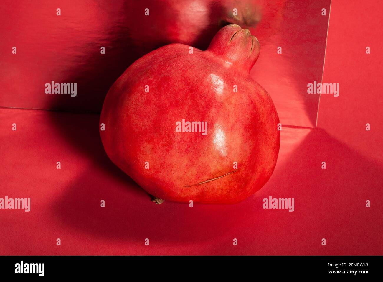 Verspiegelter Granatapfel auf rotem Hintergrund Stockfoto