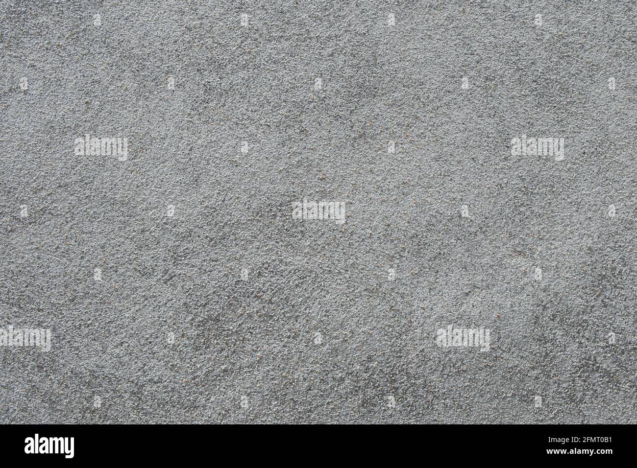 Die Textur einer grauen Oberfläche, die mit einer Mischung aus Sand und Zement bedeckt ist. Fertigstellung der Bauelemente. Selektiver Fokus. Stockfoto