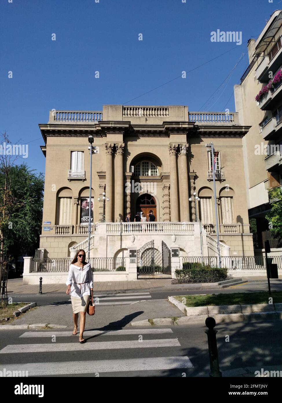 Nikola Tesla Museum und wunderschöne Frauen, die an sonnigen Tagen auf der Straße vor dem Museum spazieren. Fassade des Museums. Stockfoto