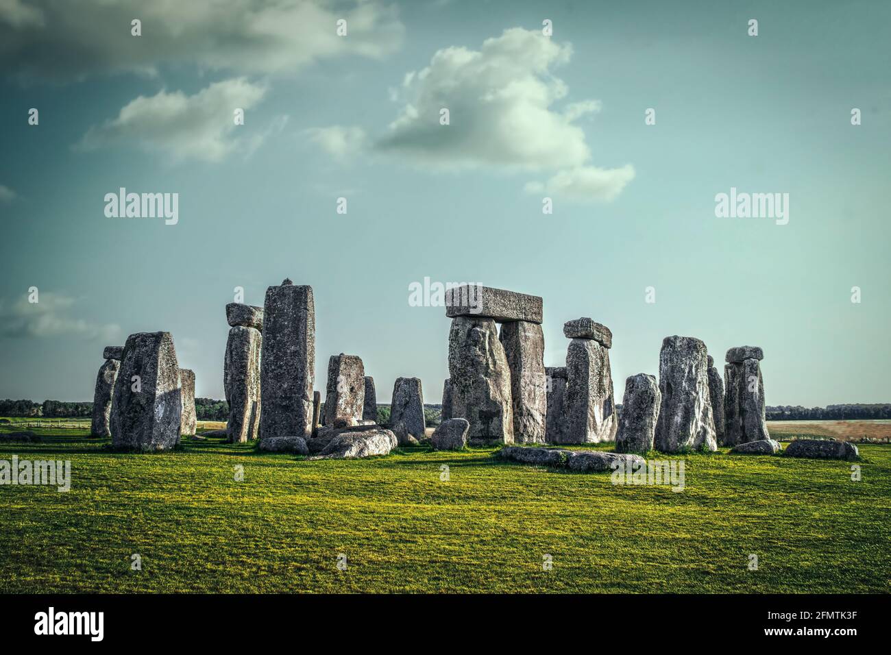 Stonehenge uralte Ruinen auf der Sailbury Plain in Großbritannien stehen Unter einem seltsamen türkisblauen Himmel mit langen Schatten Stockfoto