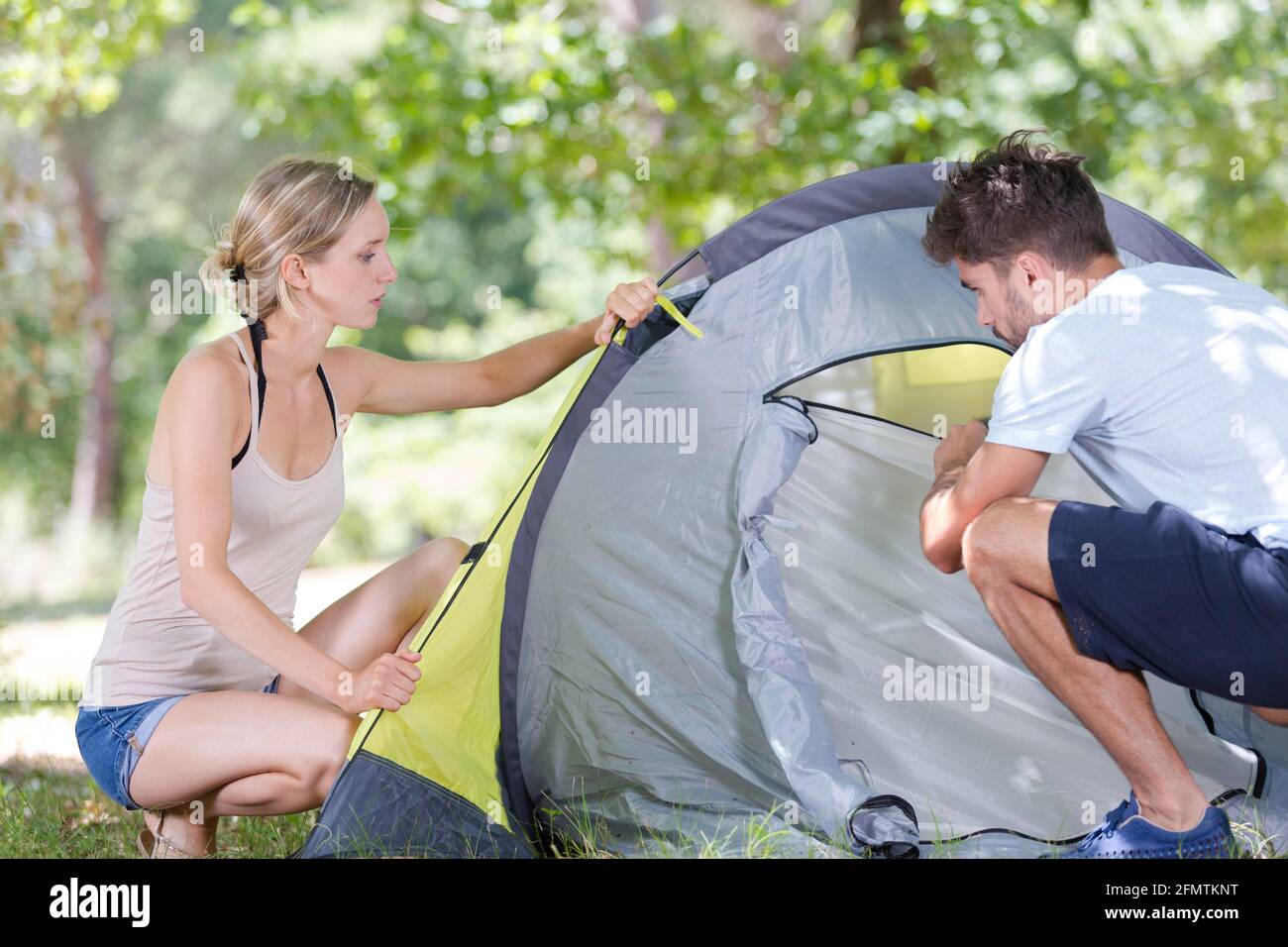 Junge Camper beim Aufstellen des Zeltes am Wald Stockfoto