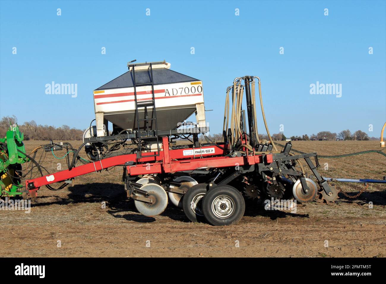 Farm Equipment in einem Farmfeld in Kansas mit blauem Himmel. Stockfoto