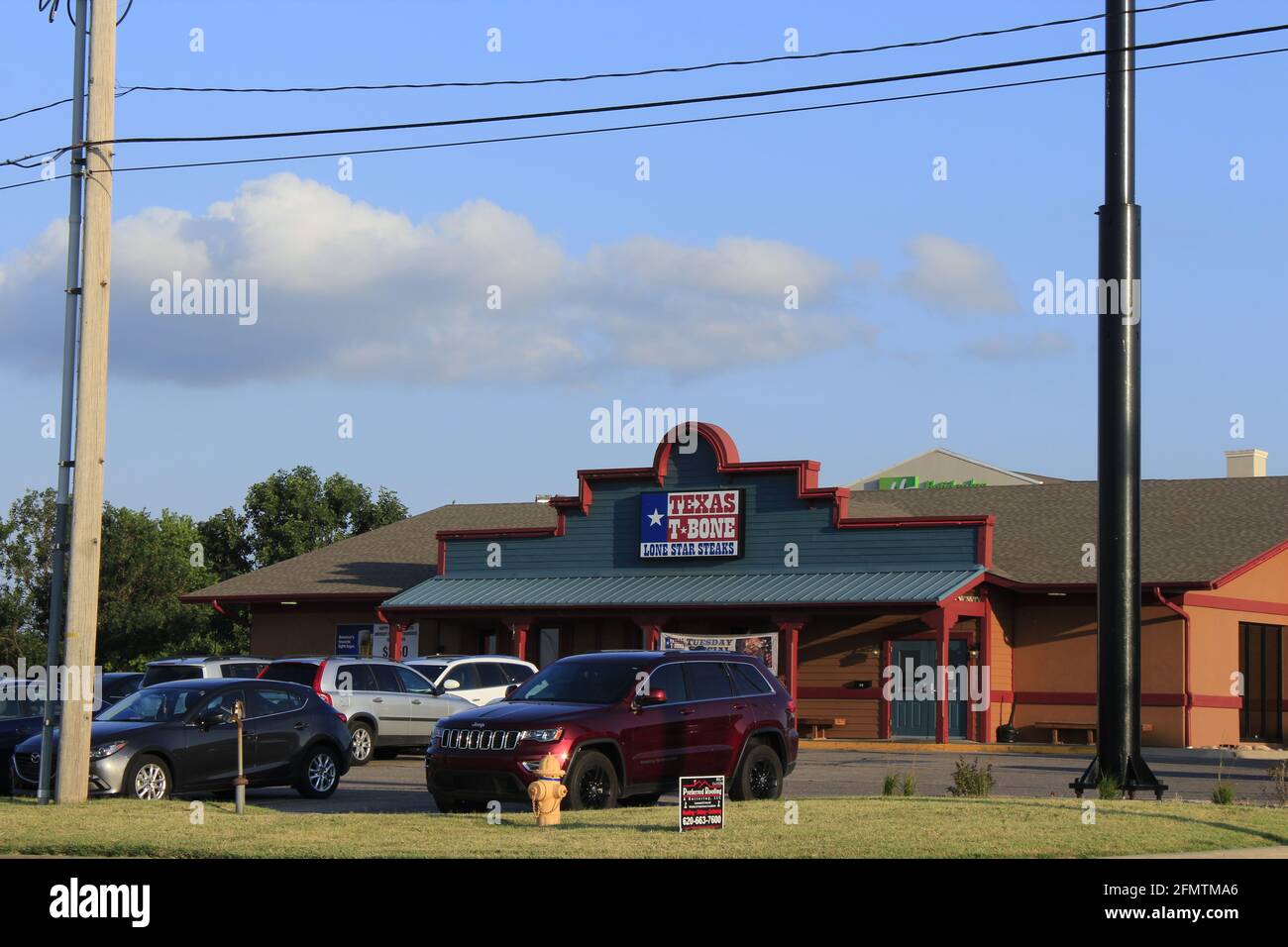 Texas T-Bone Steak House mit einem farbenfrohen blauen Himmel mit Wolken, das ist in Kansas. Stockfoto