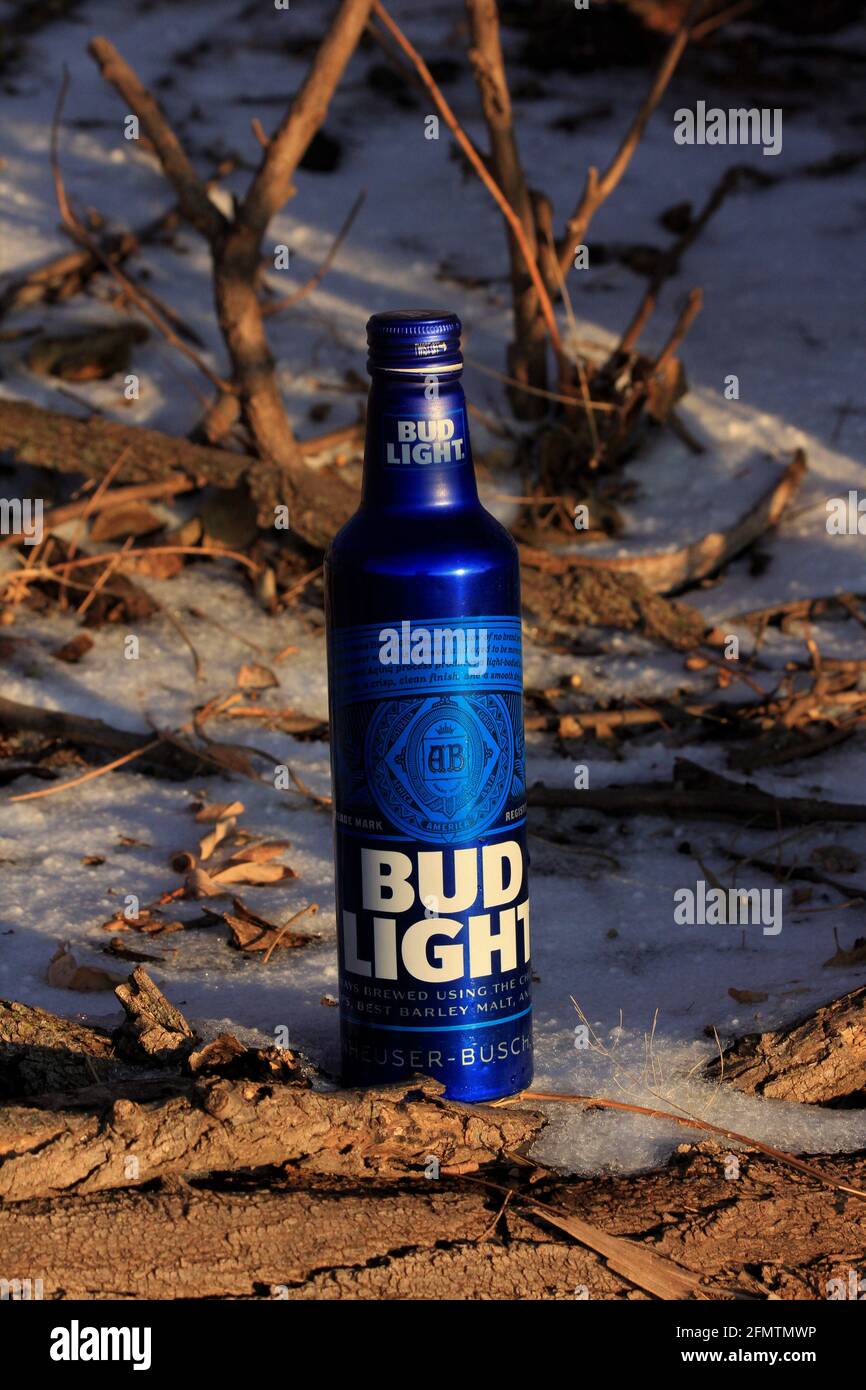 Bud Light in blau Aluminiumflaschen schossen im Winter aus der Nähe mit Schnee und kleinen Bäumen auf dem Land in Kansas. Stockfoto