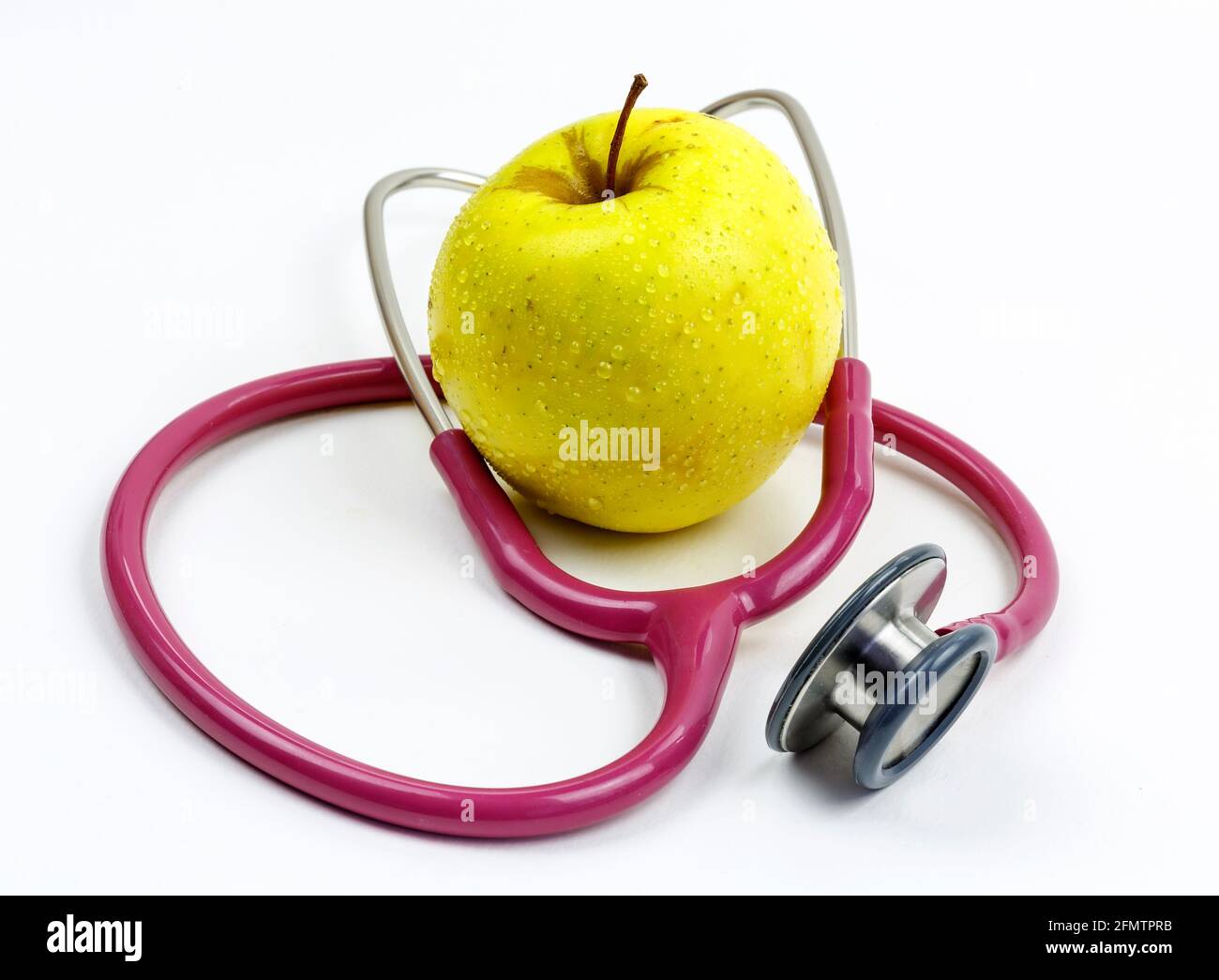 Ein Stethoskop und ein Apfel. Symbol für eine gesunde Ernährung. Stockfoto