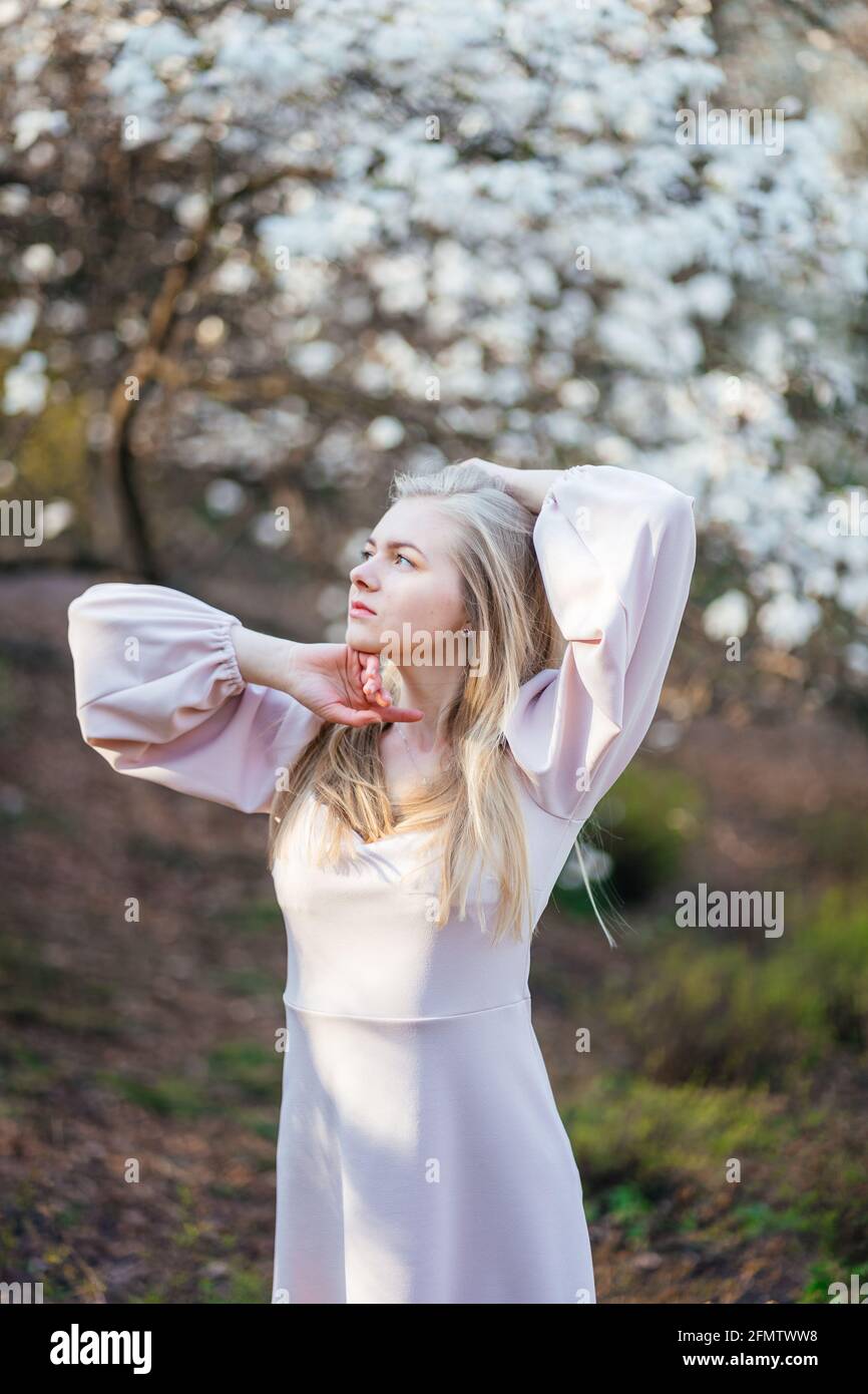 Sanftes Blondine in einem beigen Kleid im Park Stockfoto