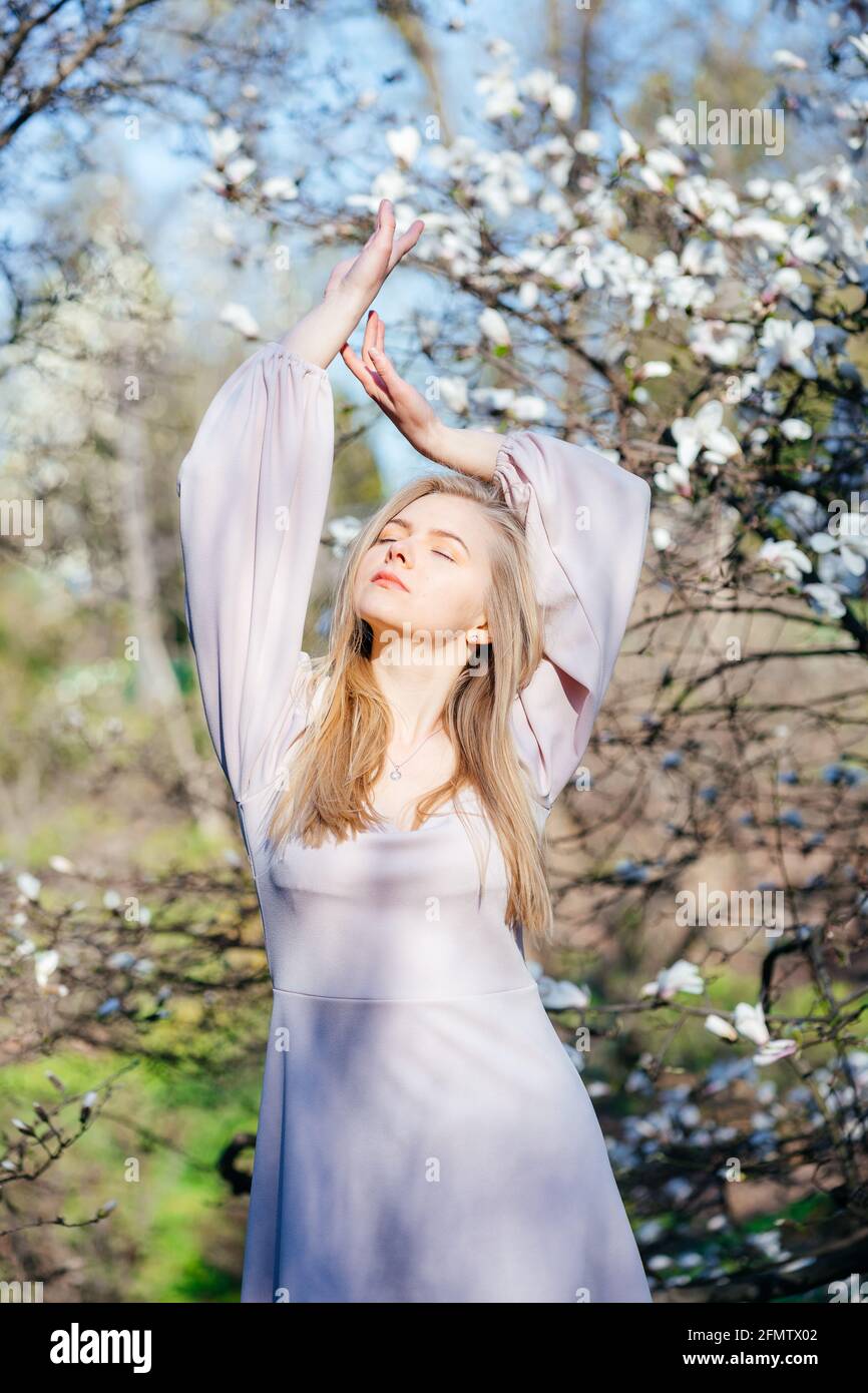 Sanftes Blondine in einem beigen Kleid im Park Stockfoto