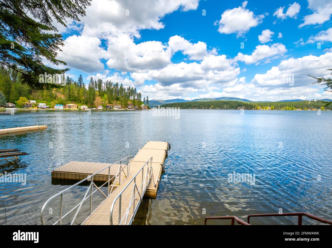 Ein kleiner Dock von einem Haus in der ländlichen Gemeinde Newman Lake, Washington, USA mit anderen Häusern am Wasser und Bootsrampen in Sicht. Stockfoto