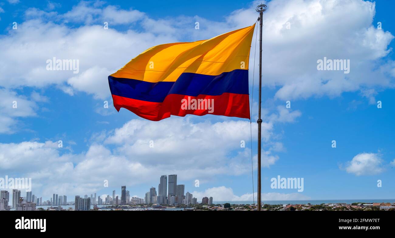 Die Flagge schwankt vor dem malerischen Blick auf die moderne Skyline von Cartagena in der Nähe des historischen Stadtzentrums und der Hotelzone des Resorts. Stockfoto