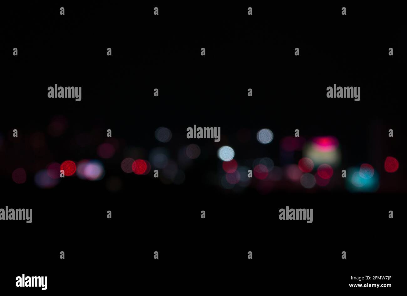 Bokeh im Vintage-Stil bei dunkler Nacht. Schöne bunte verschwommene Lichtkreise in modernen Stadt abstrakten Hintergrund. Stockfoto