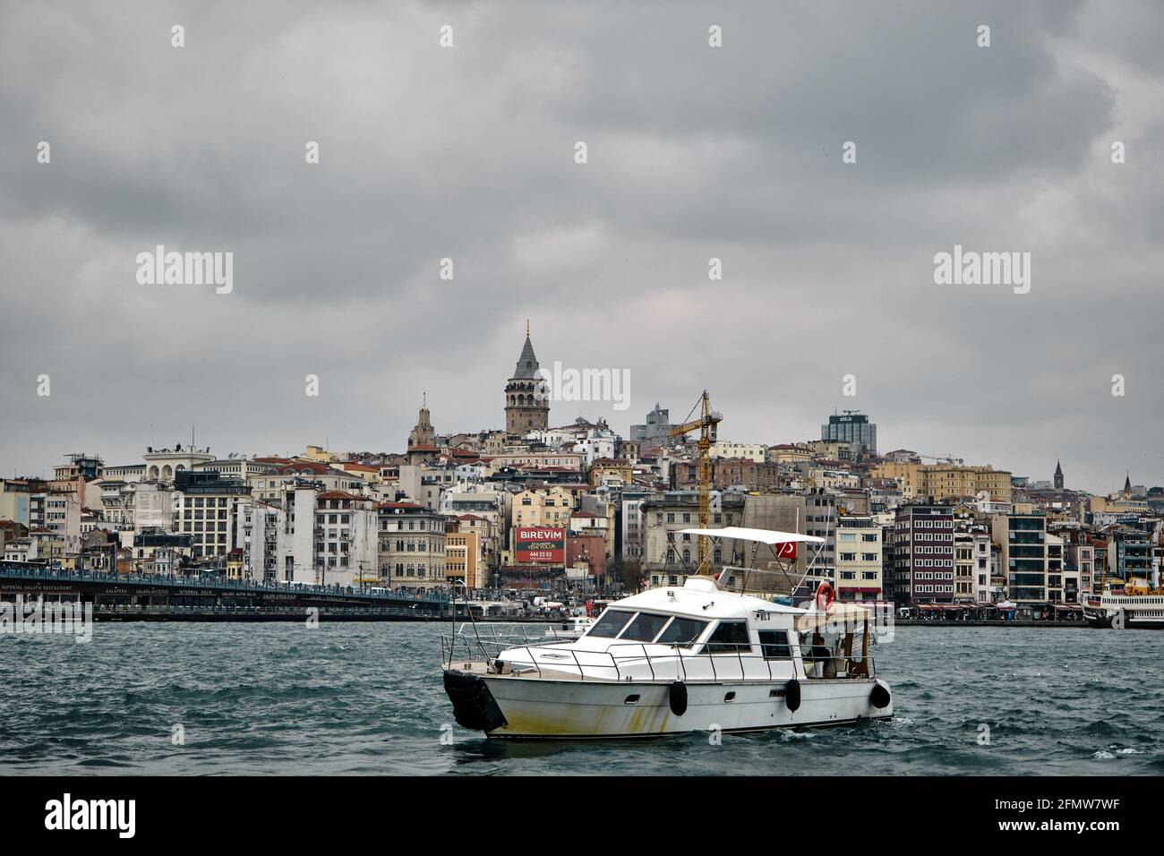 Alter und antiker Turm in istanbul, der von einem genuesischen Seemann gebaut wurde Und istanbul bosporus mit Boot und galata Brücke bei bewölktem Wetter Tag bewölktes Wetter Stockfoto