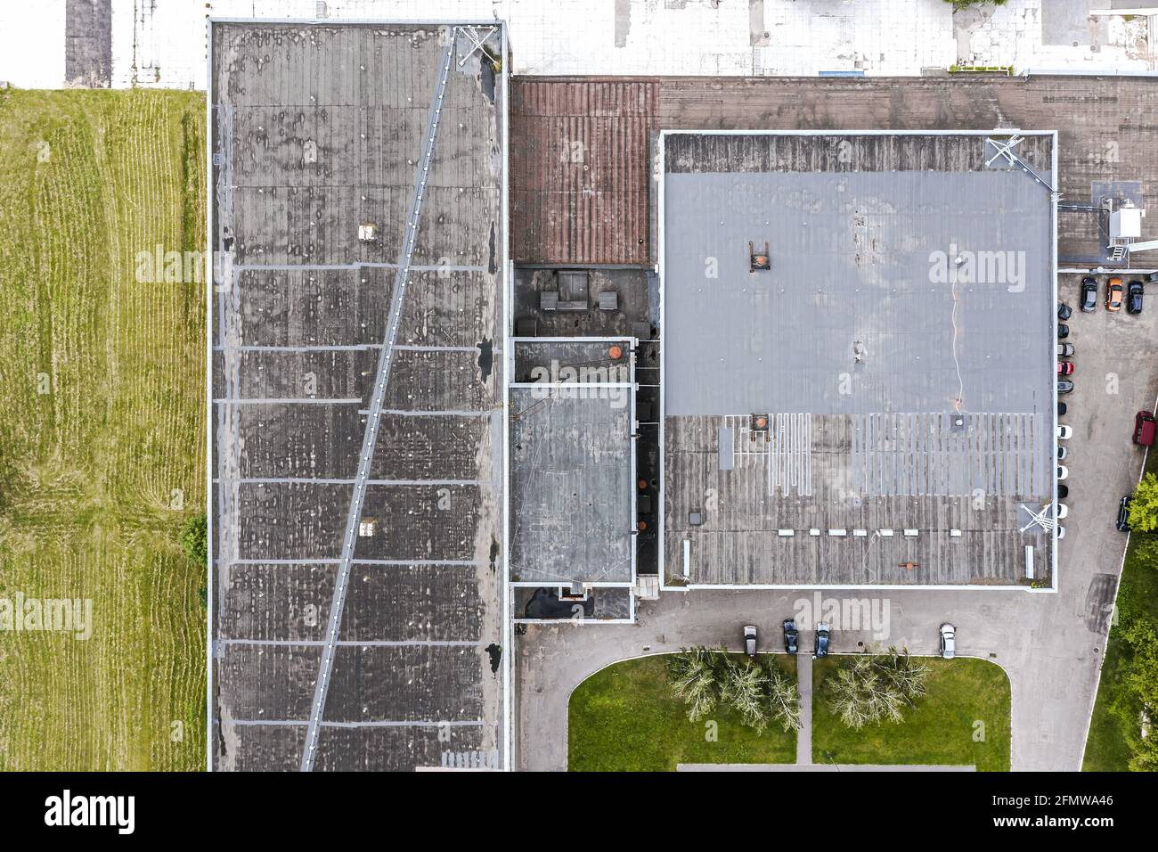 Graues Flachdach eines Industriegebäudes oder Lagerhauses. Industrieller Hintergrund. Luftaufnahme Stockfoto Graues Flachdach eines Industriegebäudes oder Lagerhauses. Industrieller Hintergrund. Luftaufnahme Stockfoto
