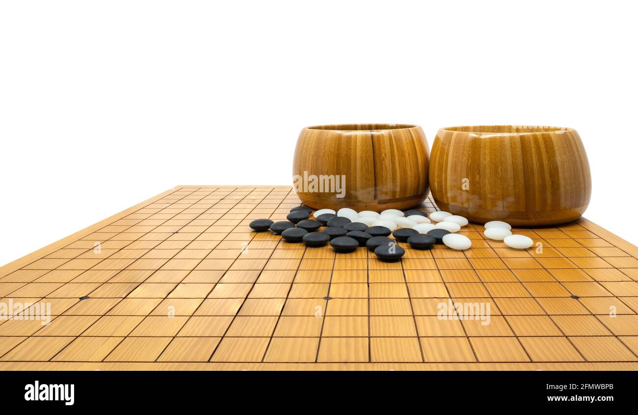 Isoliertes Go-Brettspiel oder traditionelles chinesisches altes Brettspiel, schwarze Steine, weiße Steine und zwei Holzschüsseln werden an Bord gelegt, niedriger Winkel und Pers Stockfoto