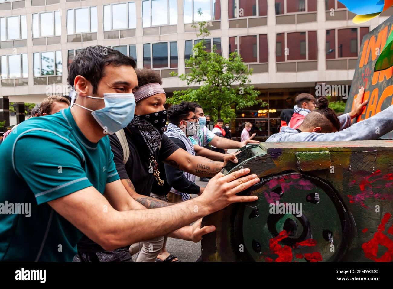 Washington, DC, USA, 11. Mai 2021. Im Bild: Während eines marsches, der die Vereinigten Staaten aufforderte, die Finanzierung von Apartheid, Besatzung und Gewalt in Palästina einzustellen, drücken Demonstranten auf einen Scheinpanzer. Der Tank ist ein Beweis für die Unterstützung der sozialen Gerechtigkeit in allen Teilen, da er für Proteste gegen die Niederschlagung von Demonstranten in Kolumbien gebaut wurde. Kredit: Allison C Bailey / Alamy Live Nachrichten Stockfoto