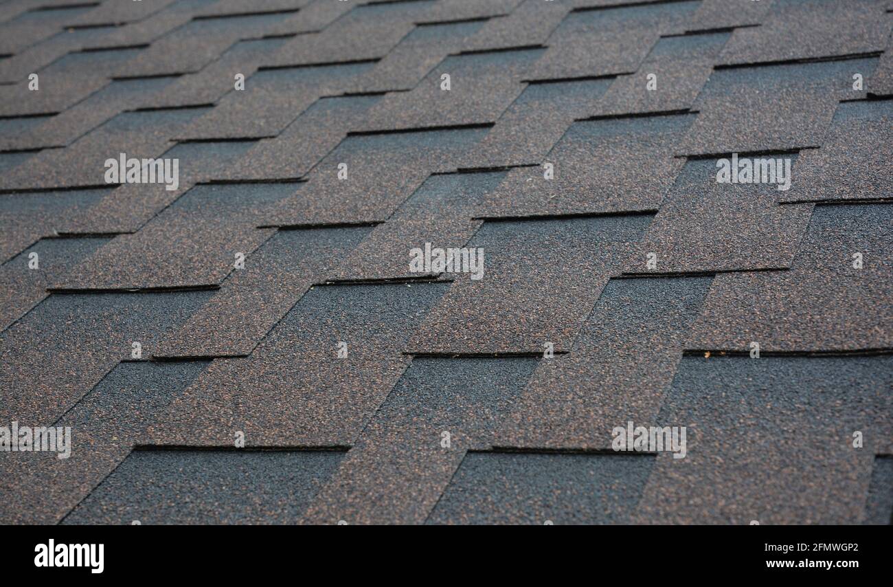 Architektonische, dimensionale Asphalt Schindeln Dachmaterial Hintergrund. Braun, Kupfer Asphalt Schindeldach Textur. Stockfoto
