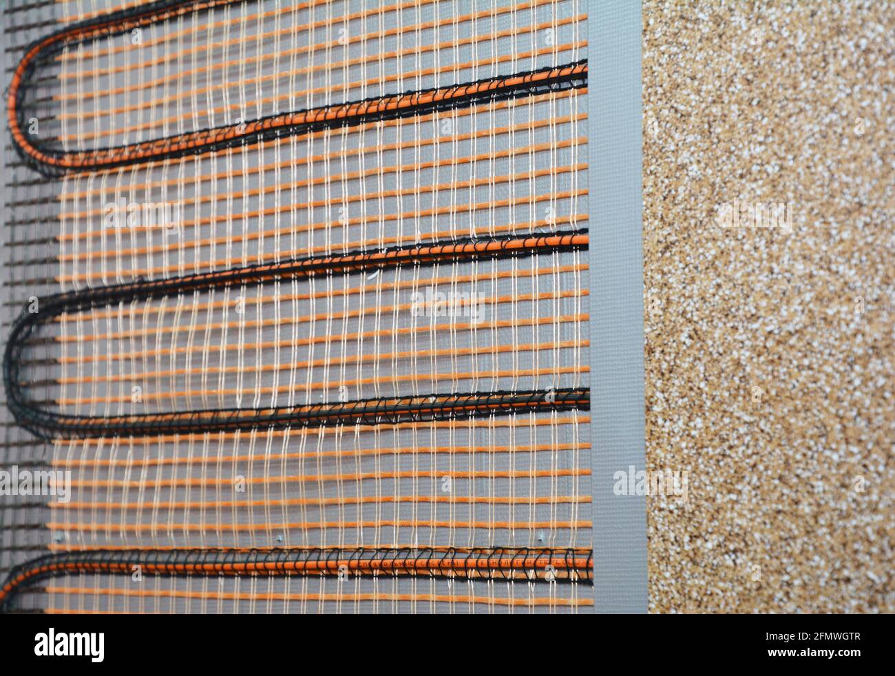 Nahaufnahme eines elektrischen Heizstrahlers an der Wand. Wartung des elektrischen Heizstrahlsystems. Stockfoto Nahaufnahme eines elektrischen Heizstrahlers an der Wand. Wartung des elektrischen Heizstrahlsystems. Stockfoto