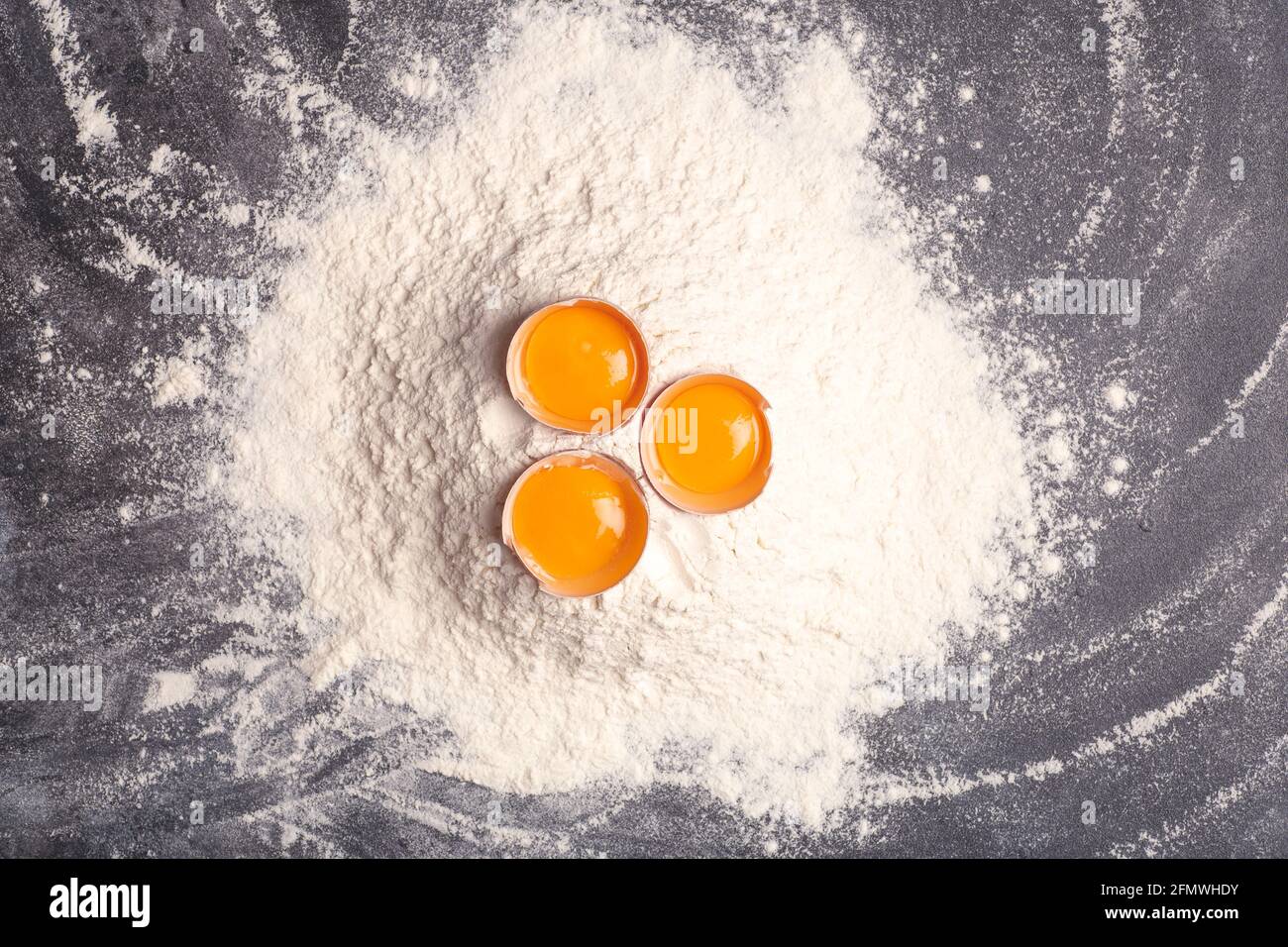 Teig, Backen und Kochen Hintergrund. Mehl und Eier auf dunklem Holz-Küchenhintergrund als Zutaten für ein Rezept und Teiggerichte. Hochwertige Fotos Stockfoto