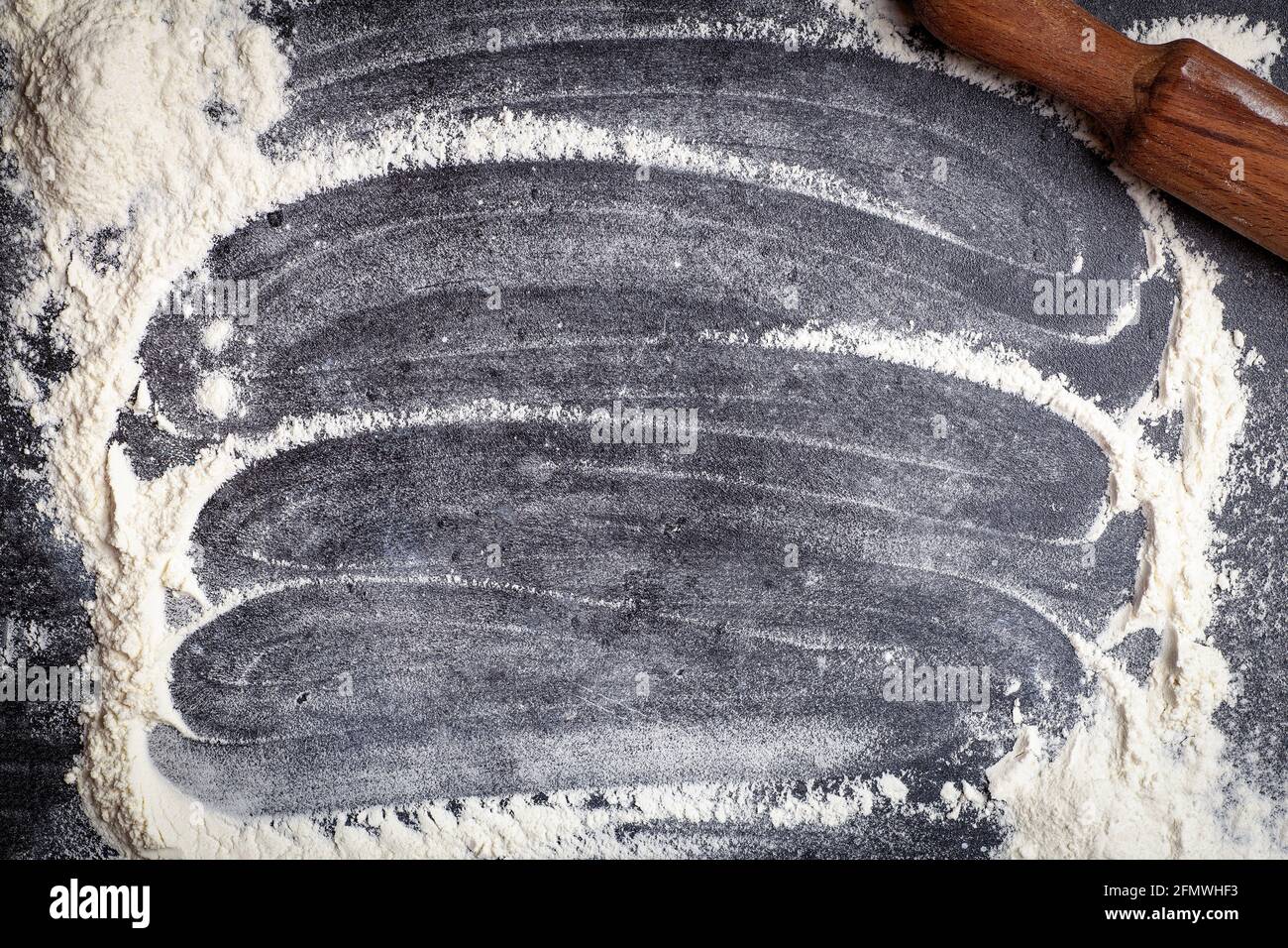 Teig, Pasta, Pizzabacken und Kochen Hintergrund. Mehl auf dunklem Holz-Küchenhintergrund als Zutaten für ein Rezept und Teiggerichte. Hochwertige Fotos Stockfoto