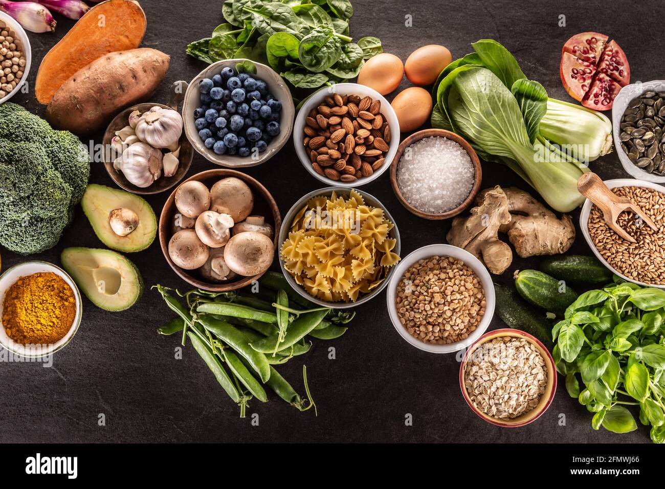 Auswahl an frischen Lebensmitteln und gesunder Ernährung: Gemüse, Obst, Hülsenfrüchte und Getreide auf einem Betontisch - Top of view. Stockfoto